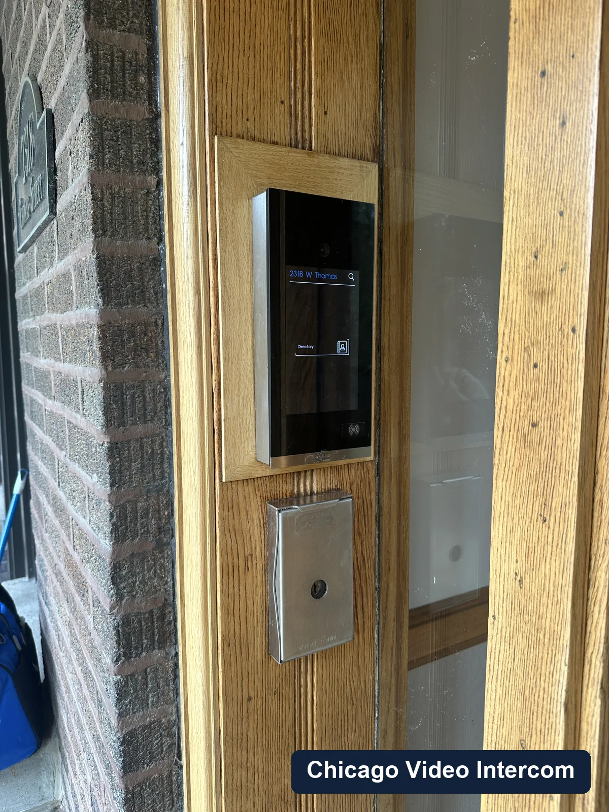 Video intercom panel installed in wood trim at a Chicago entry